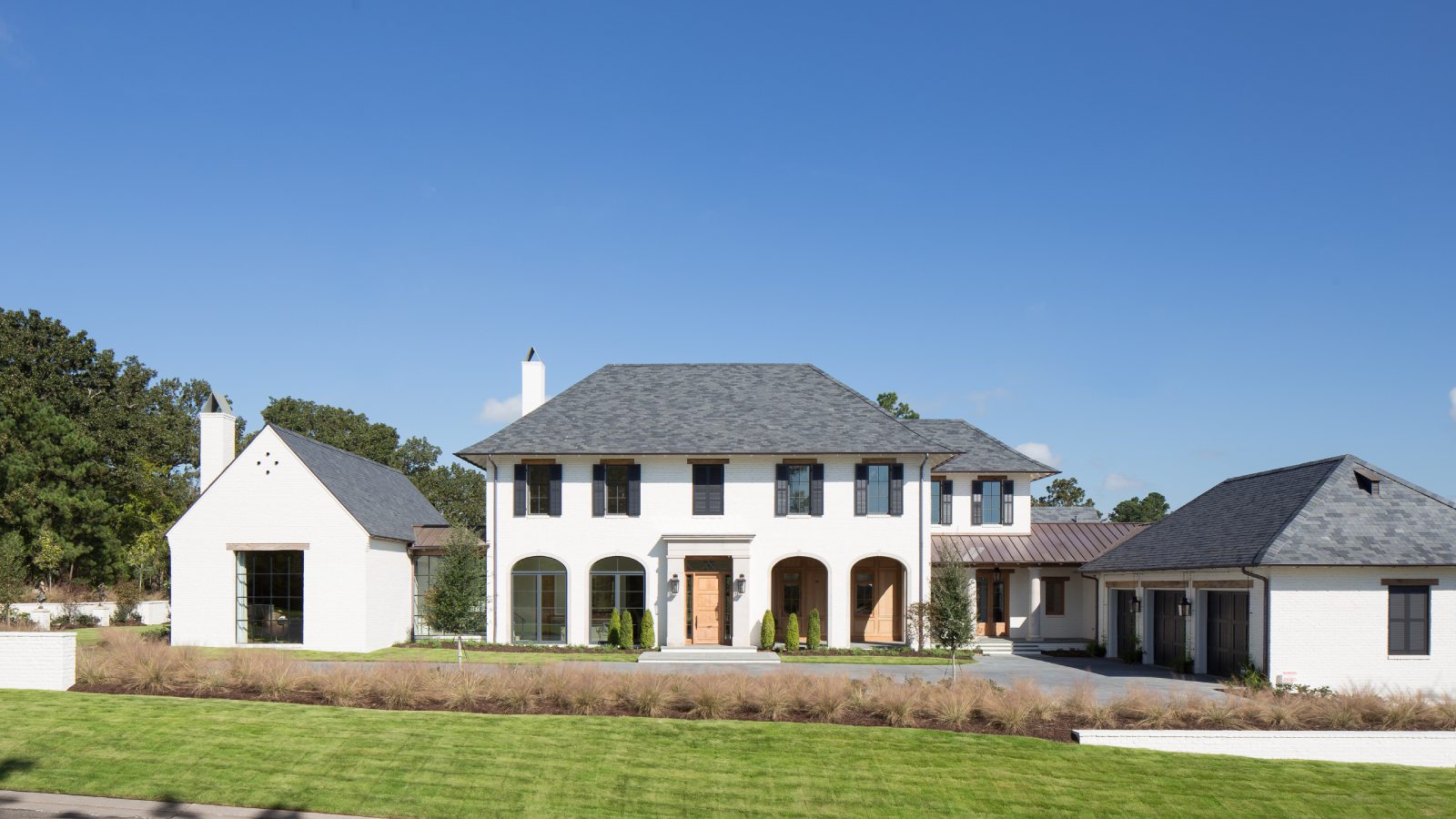 Exterior view of the front of French Influential, a custom home designed and built by Farmer Payne Architects.
