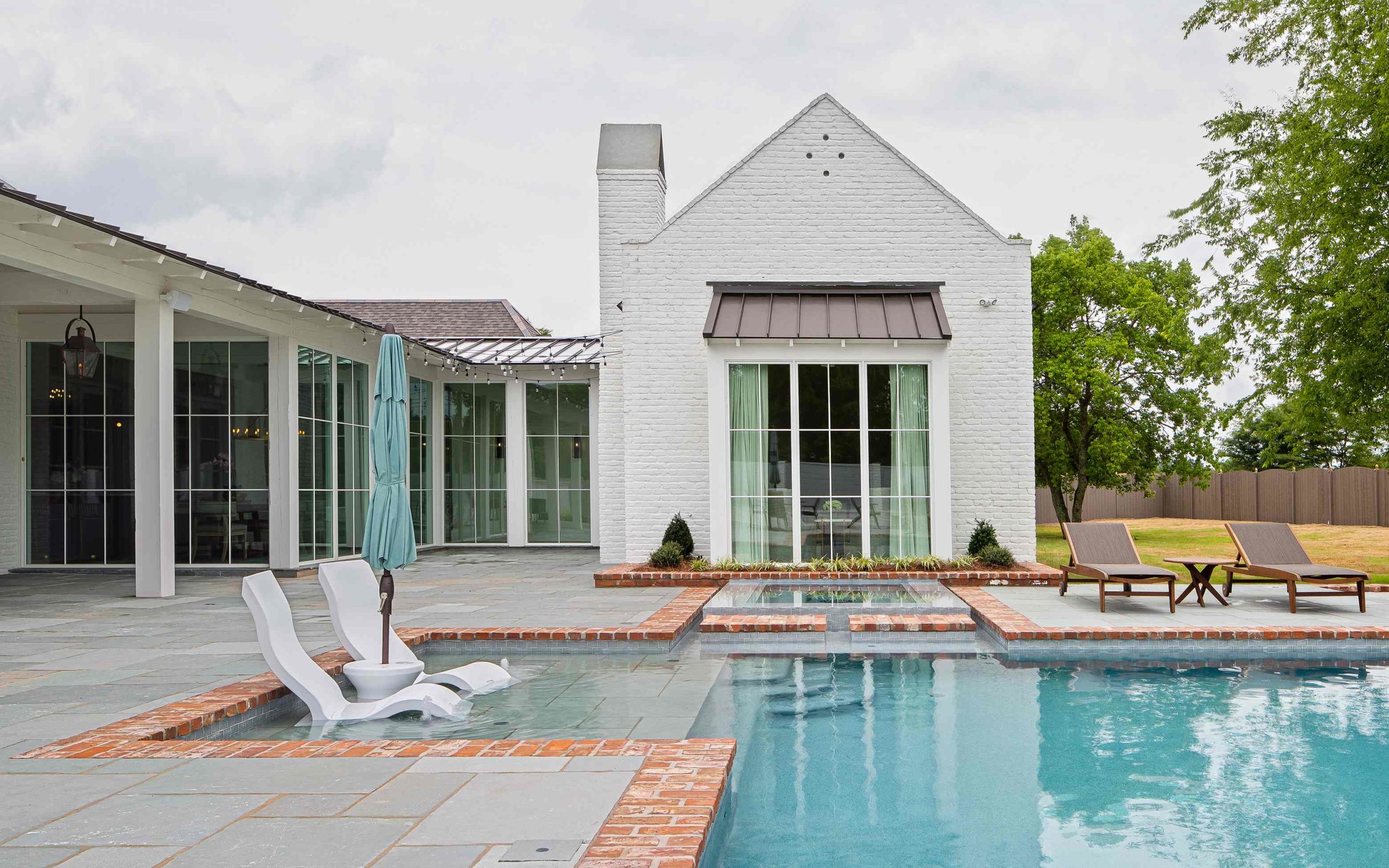 Exterior view of the back patio and pool at Oak Alley, a custom home designed and built by Farmer Payne Architects.