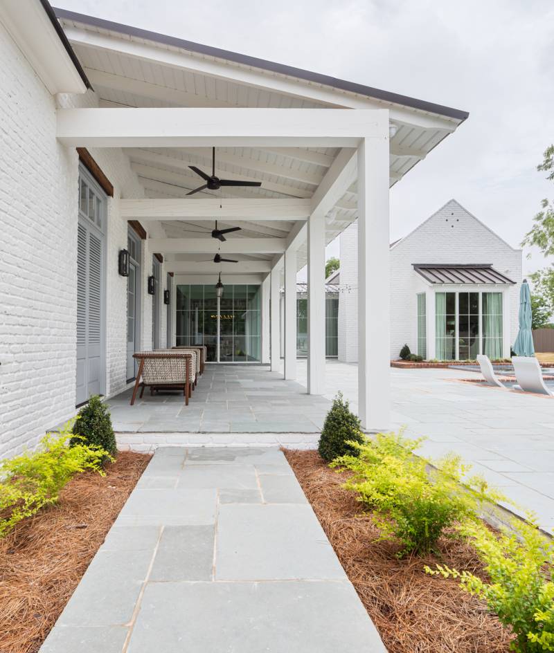 Exterior view of the back porch and patio at Oak Alley, a custom home designed and built by Farmer Payne Architects.