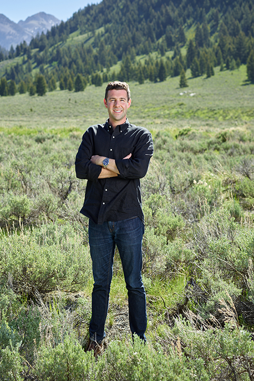Farmer Payne Architects Project Manager Casey Burke stands in a field in Jackson Hole.