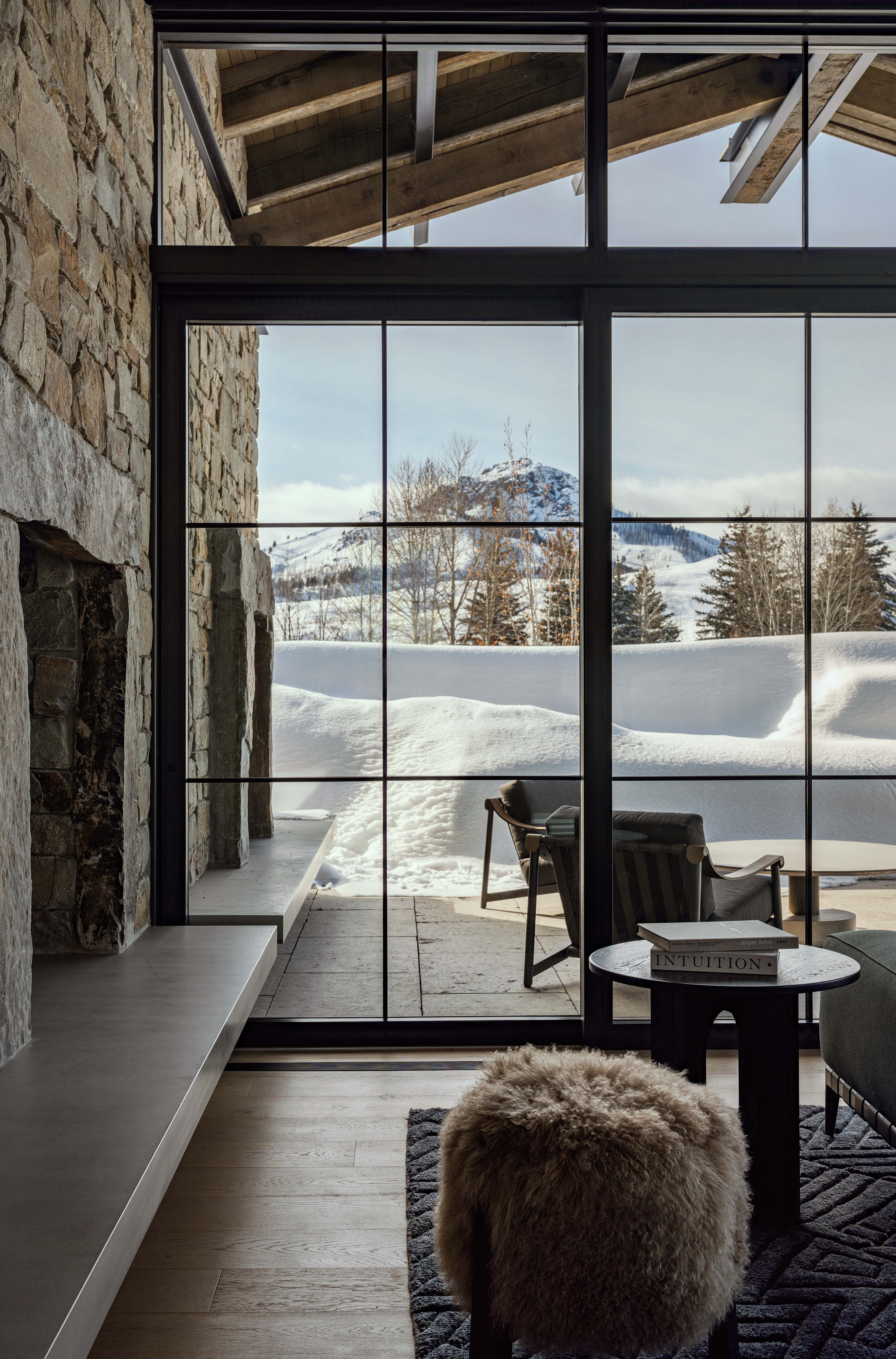 contemporary mountain home living room, featuring floor to ceiling windows showcasing surrounding views and outdoor patio