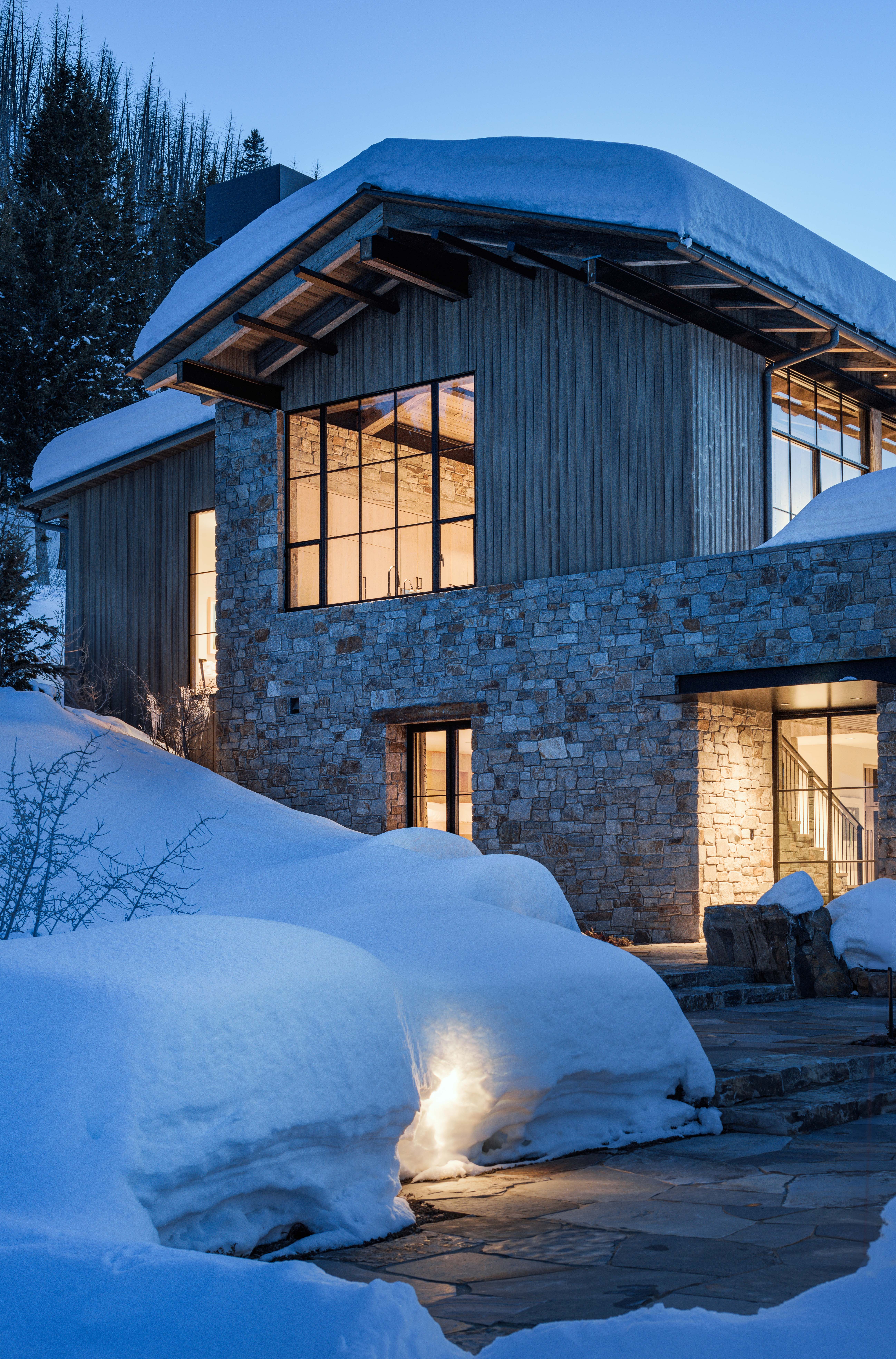 contemporary mountain home exterior, featuring lit up windows and interior views of home