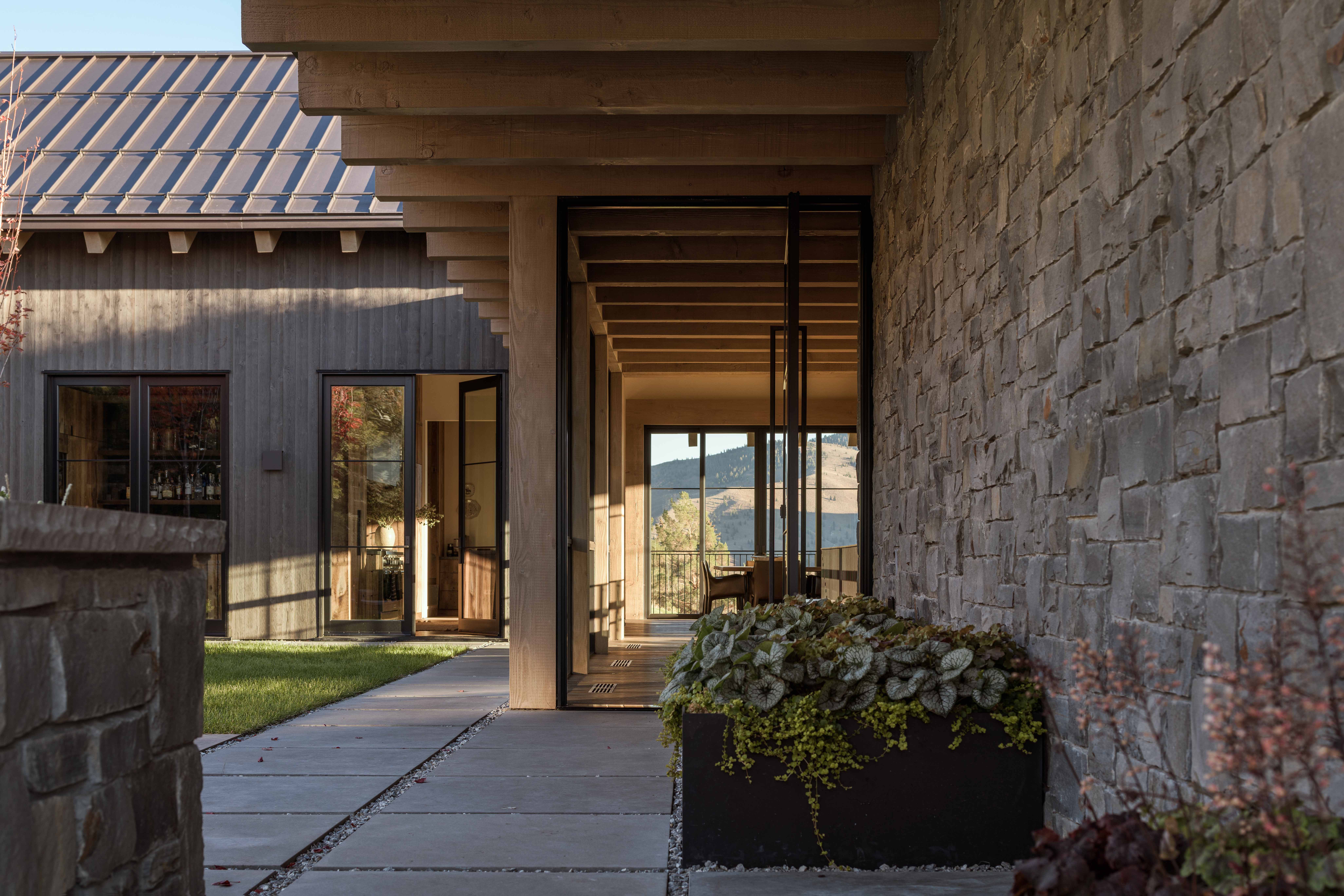 contemporary mountain home entryway, featuring sunken courtyard underneath a cantilevered green roof