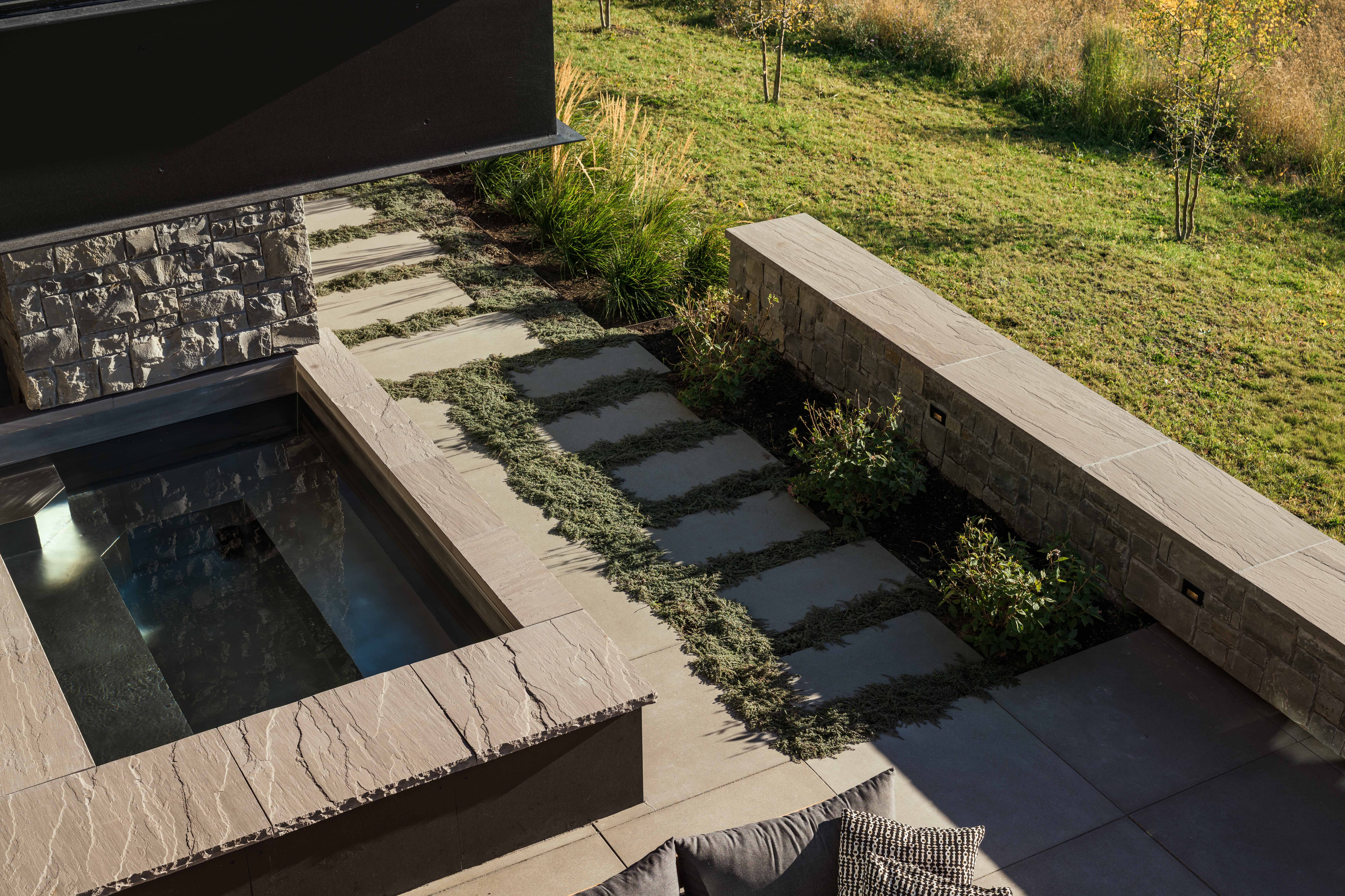 contemporary mountain home outdoor custom hot tub, protected by cantilevered floor above