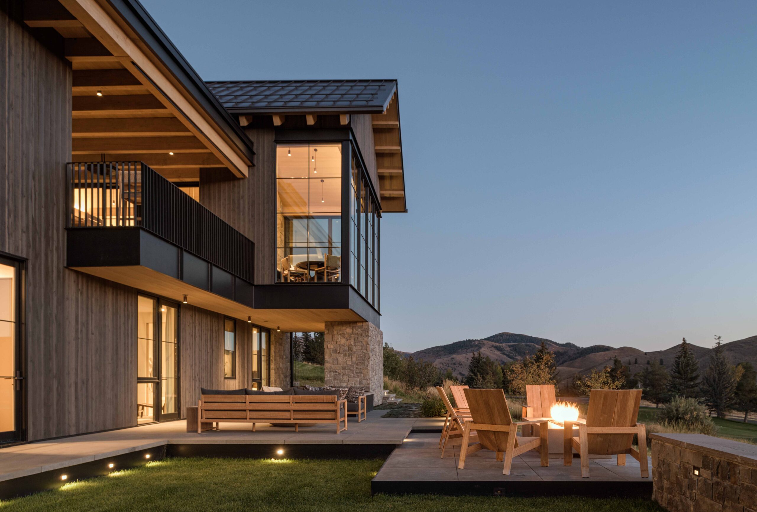 contemporary mountain home exterior, featuring patio space and an outdoor fire pit.