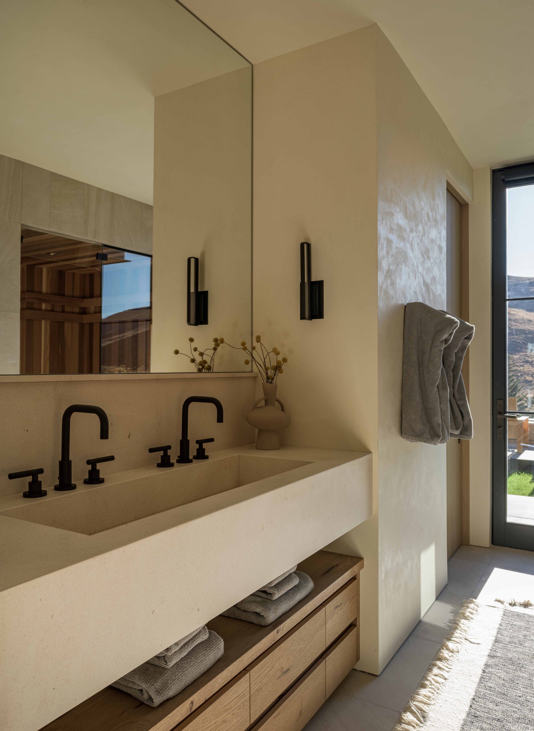 contemporary mountain home bathroom, plaster walls, featuring a floating sink with double faucets